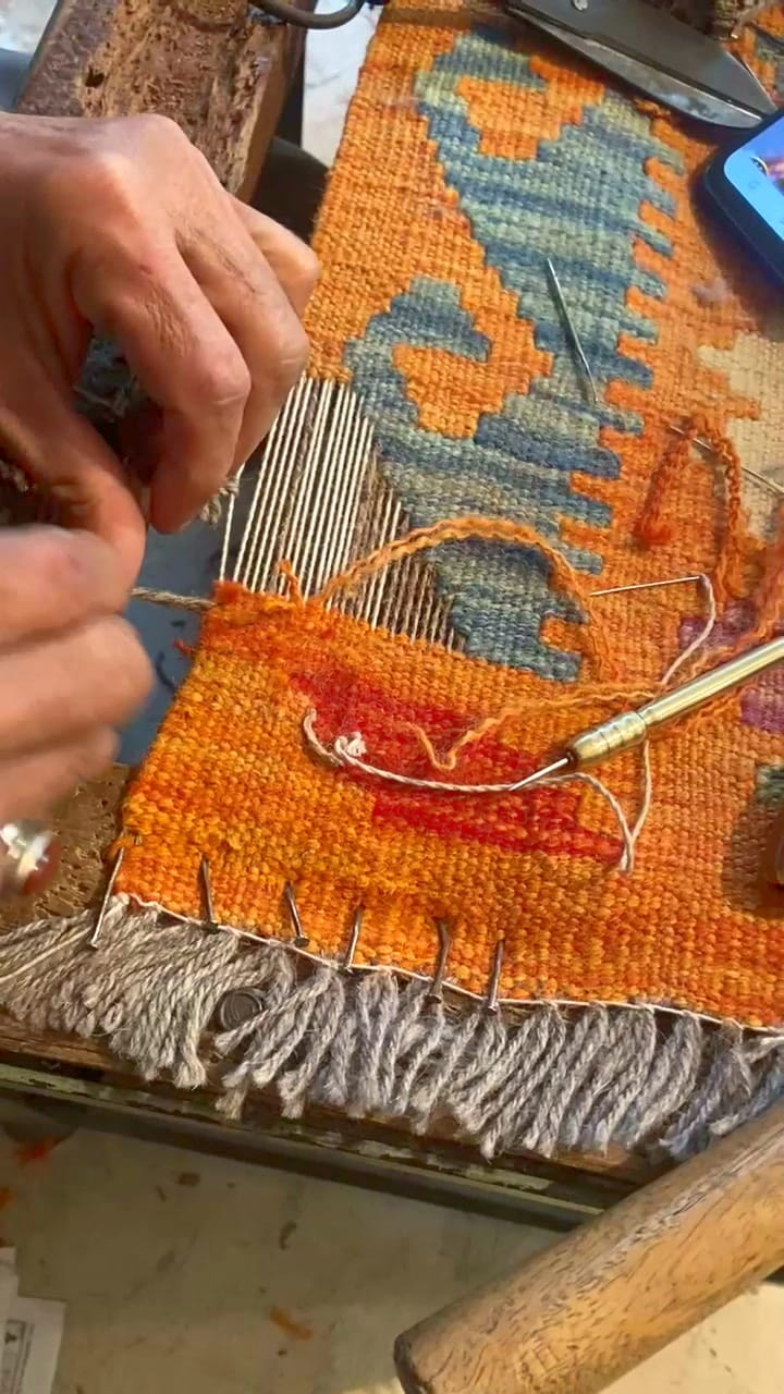 Load video: A skilled weaver weaving a maimana kilim with bare hands.