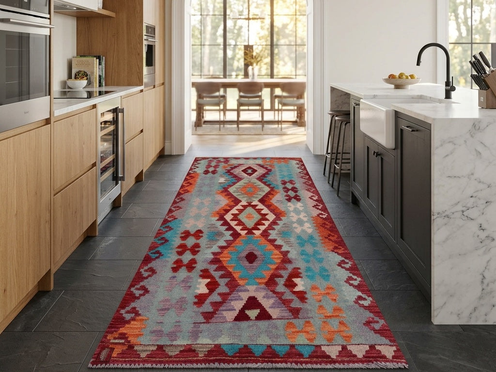 Red, teal and orange kilim runner in a kitchen with oak cabinets and a marble island