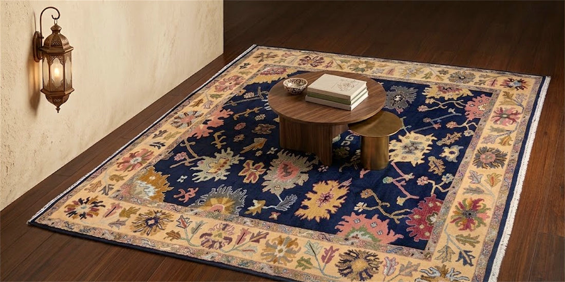 Navy and gold rug with a floral medallion border on a dark wood floor, beside a brass wall lantern